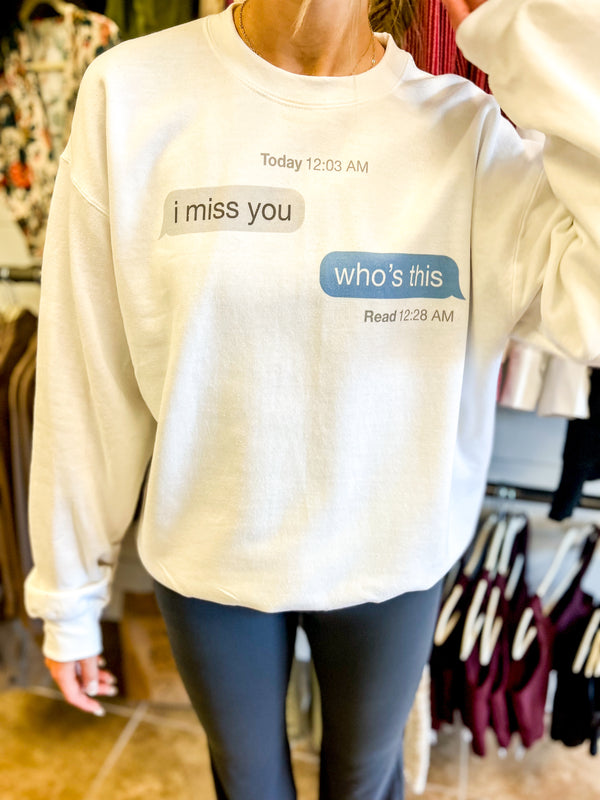 White crew neck sweat shirt that has two text message boxes that say " i miss you". Next box says "who's this"